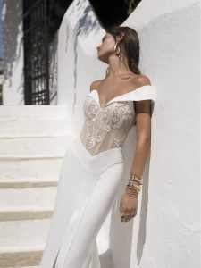 Roxanne is an off shoulder crepe bridal gown with decadent lace and detailing.